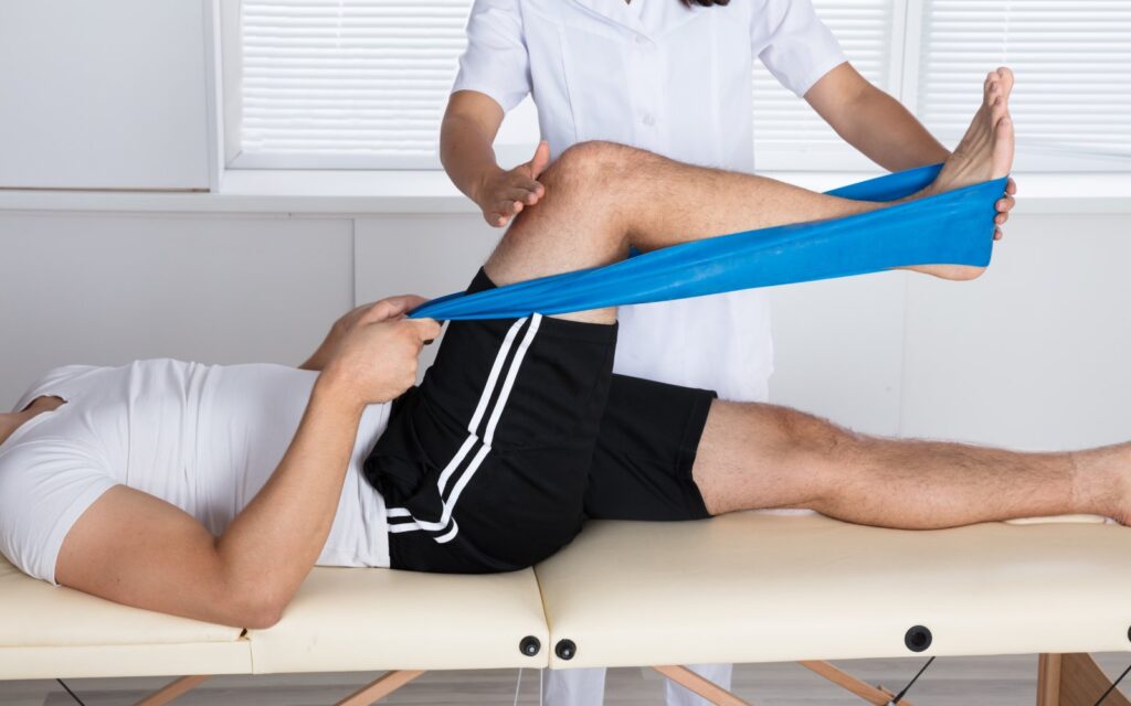 Physiotherapist Helping Patient While Stretching His Leg