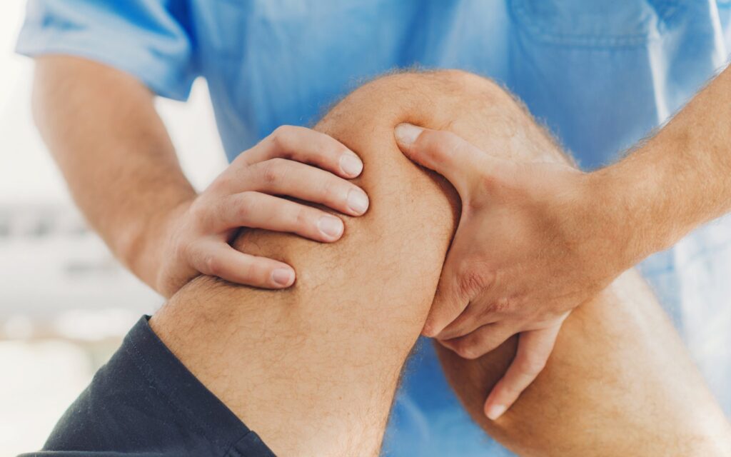 Physiotherapist doing healing treatment on patient leg